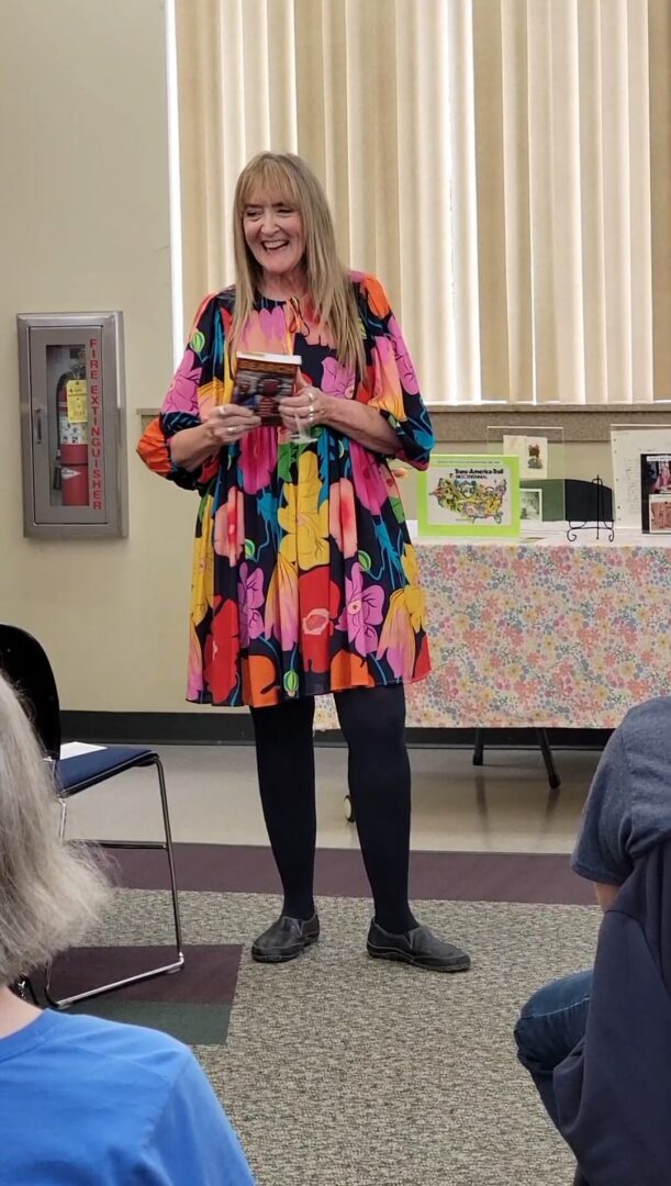 Smiling woman in colorful dress holding book